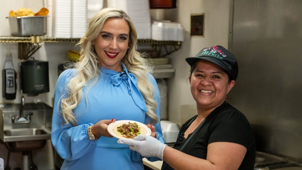 Abogada Alexandra and a staff from El Taco Mexico a woman holding a plate of tacos in a kitchen - Tacos y Tequila