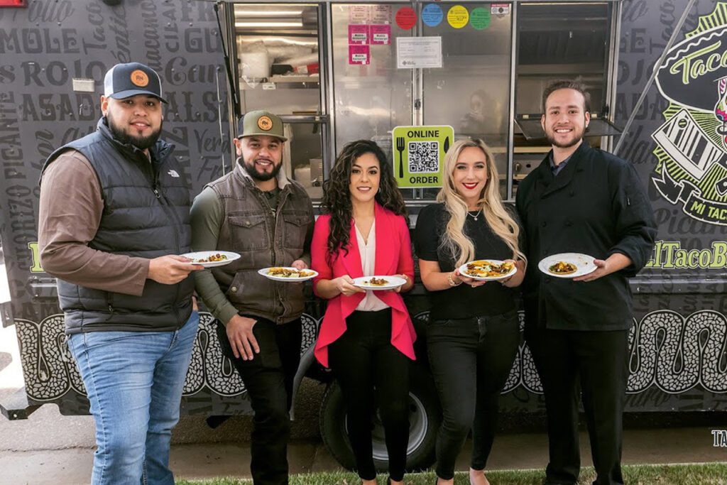 Abogada ALexandra, Jonathan and customers holding Tacos in front of the food truck -Tacos y Tequila